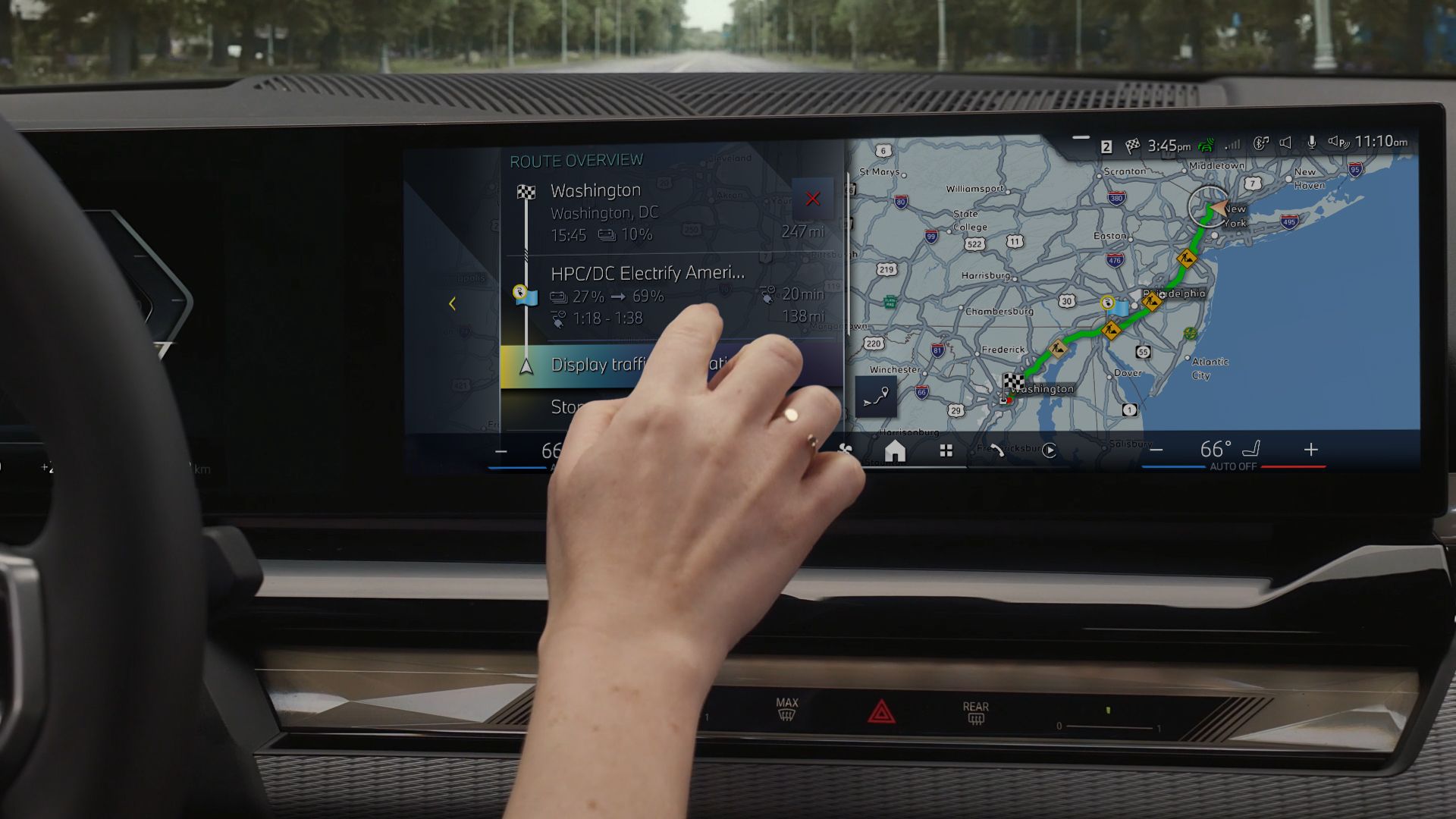 A point of view shot of a woman inputting coordinates into the BMW navigation on her display screen.